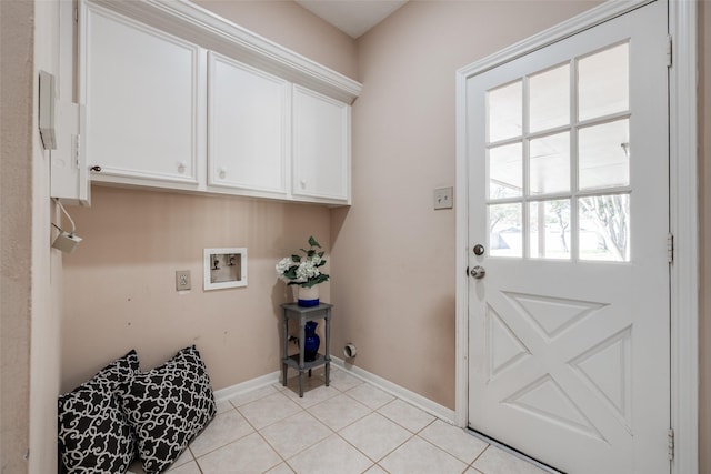 laundry room featuring hookup for a washing machine, light tile patterned floors, cabinet space, and baseboards