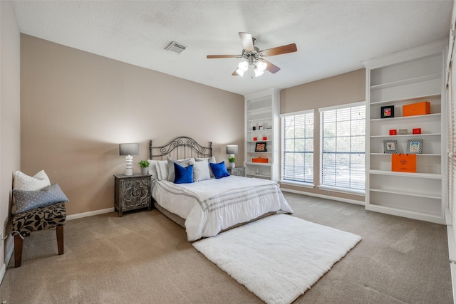 carpeted bedroom featuring visible vents, baseboards, a textured ceiling, and ceiling fan