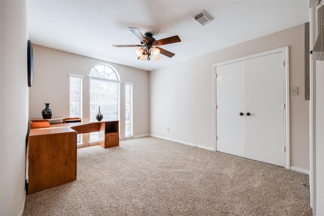 office space with baseboards, carpet, visible vents, and ceiling fan