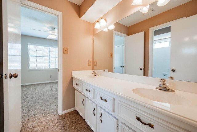 bathroom with double vanity, a ceiling fan, baseboards, and a sink