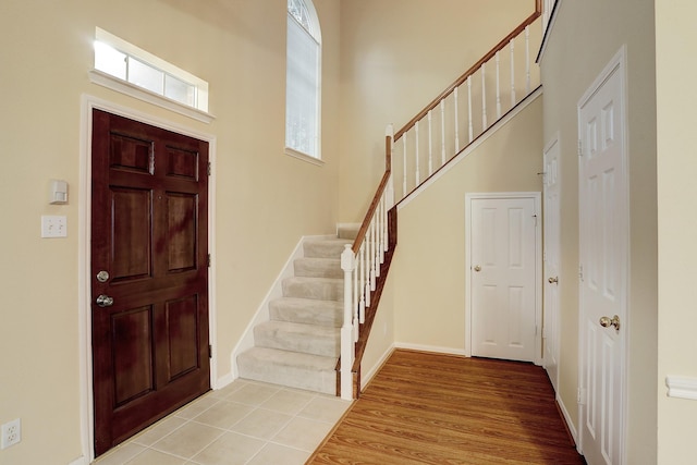 1373 El Camino Village Dr, Houston, TX 77058 - foyer featuring light wood finished floors, stairs, a high ceiling, and baseboards