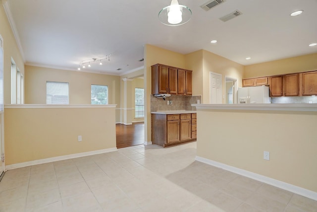 1373 El Camino Village Dr, Houston, TX 77058 - kitchen featuring visible vents, white fridge with ice dispenser, brown cabinetry, and light countertops