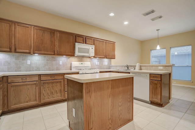 1373 El Camino Village Dr, Houston, TX 77058 - kitchen featuring white appliances, visible vents, a peninsula, a sink, and decorative backsplash