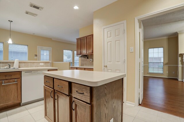 1373 El Camino Village Dr, Houston, TX 77058 - kitchen with visible vents, white dishwasher, light countertops, light tile patterned floors, and decorative backsplash