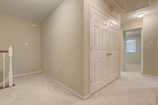 1373 El Camino Village Dr, Houston, TX 77058 - hall with baseboards, light carpet, a textured ceiling, and attic access