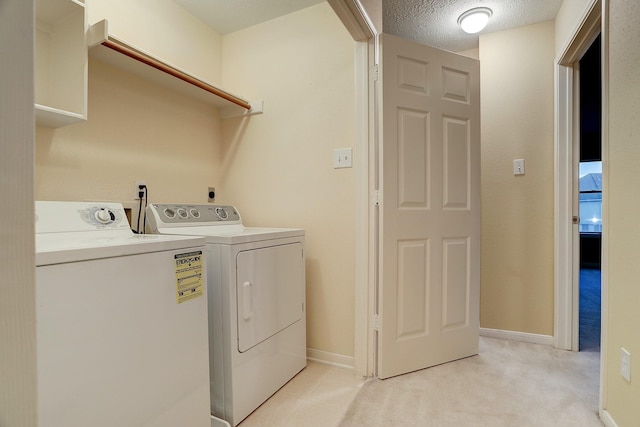 1373 El Camino Village Dr, Houston, TX 77058 - laundry room featuring washing machine and clothes dryer, baseboards, light carpet, laundry area, and a textured ceiling