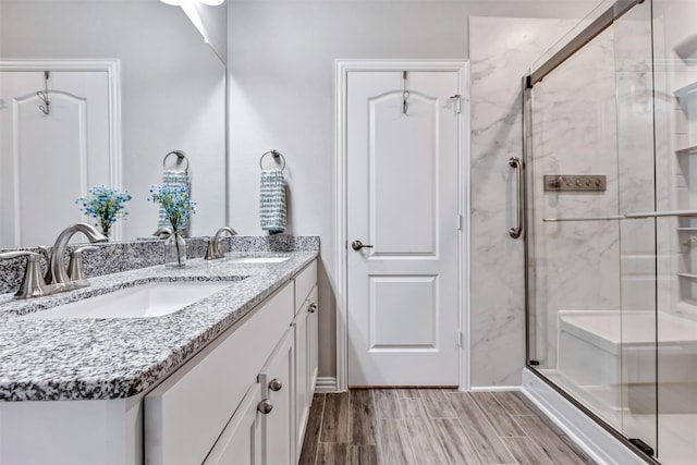 bathroom with a sink, a stall shower, and wood tiled floor