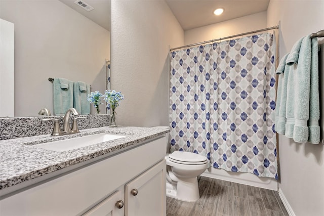 bathroom with vanity, wood finished floors, visible vents, shower / bath combination with curtain, and toilet