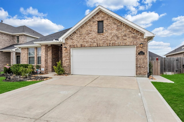 view of front of house with an attached garage, fence, brick siding, and driveway