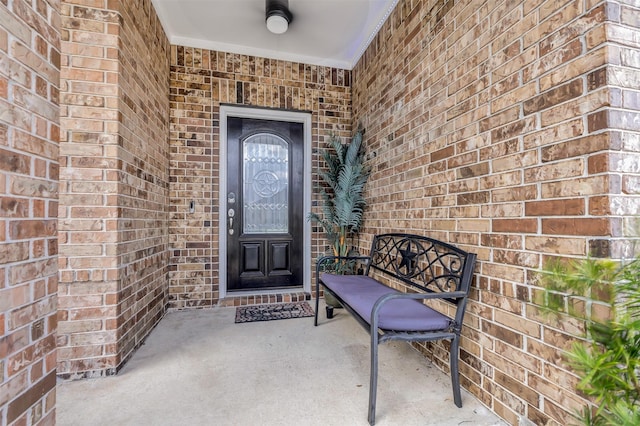 entrance to property featuring brick siding