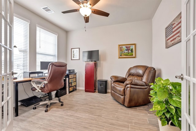 office space featuring visible vents, baseboards, light wood-style flooring, french doors, and a ceiling fan