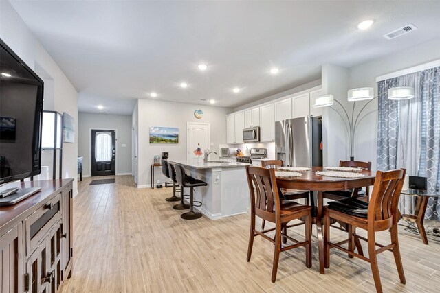 dining space featuring light wood-style flooring, recessed lighting, and visible vents