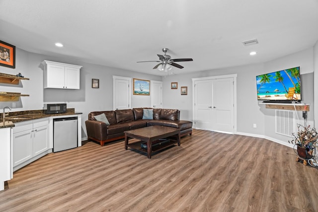 living room with light wood-type flooring, visible vents, recessed lighting, baseboards, and ceiling fan