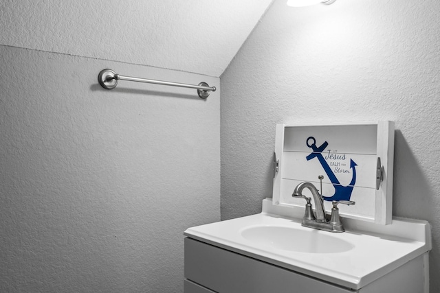 bathroom with vanity and a textured wall