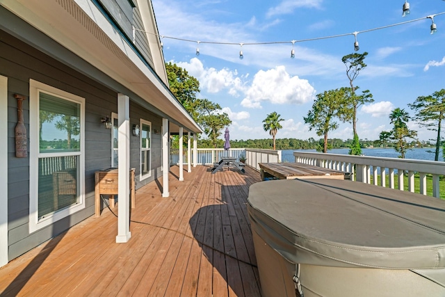 wooden terrace featuring outdoor dining area and a water view