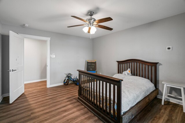 bedroom featuring ceiling fan, baseboards, and wood finished floors