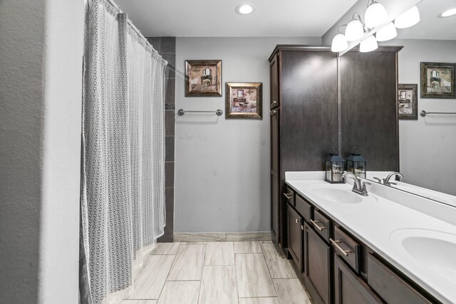 bathroom with double vanity, a shower with shower curtain, and a sink