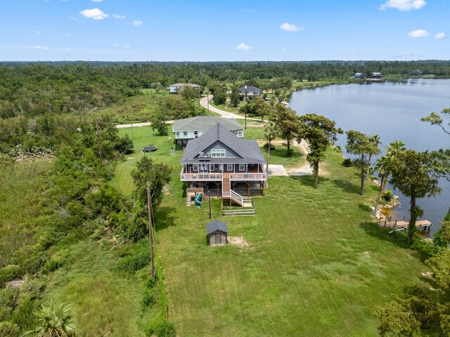 drone / aerial view with a wooded view and a water view