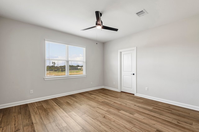 unfurnished room featuring visible vents, a ceiling fan, baseboards, and wood finished floors