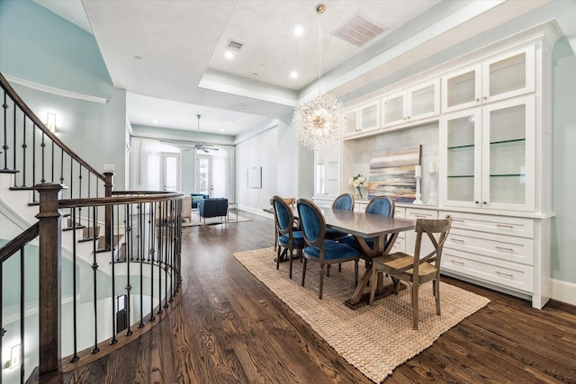 dining area featuring visible vents, baseboards, dark wood-style flooring, and ceiling fan with notable chandelier