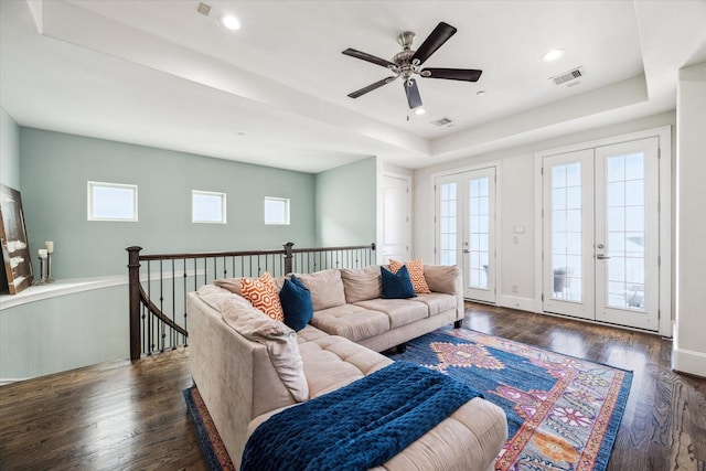 living room with ceiling fan, visible vents, and wood finished floors