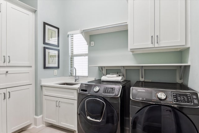 laundry room featuring a sink, cabinet space, light tile patterned flooring, and washing machine and clothes dryer