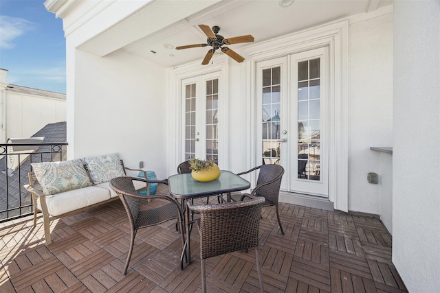 balcony with french doors and a ceiling fan