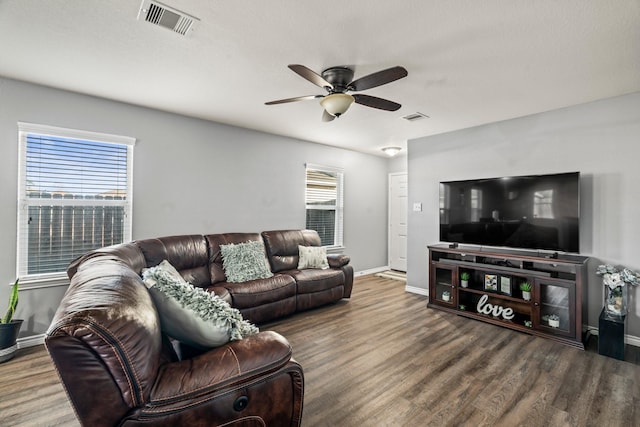 living area featuring visible vents, baseboards, ceiling fan, and wood finished floors