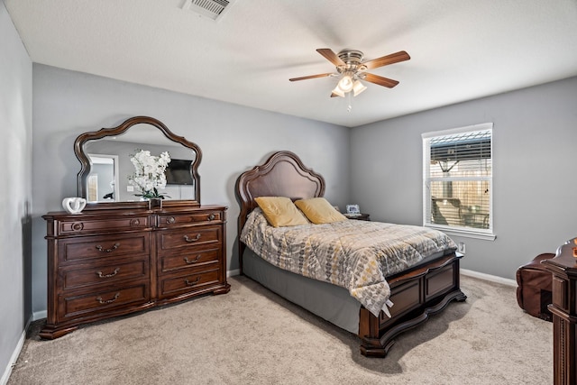 bedroom with ceiling fan, light colored carpet, visible vents, and baseboards