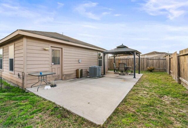 rear view of property with central air condition unit, a patio, a fenced backyard, a gazebo, and a yard