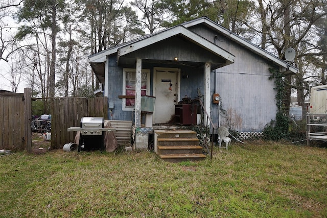 bungalow with a front yard and fence