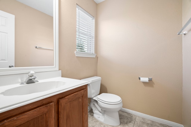 bathroom featuring vanity, toilet, baseboards, and tile patterned flooring