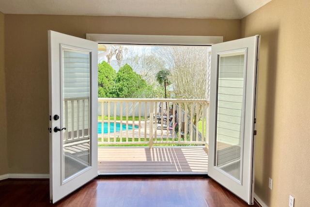 doorway with baseboards and wood finished floors