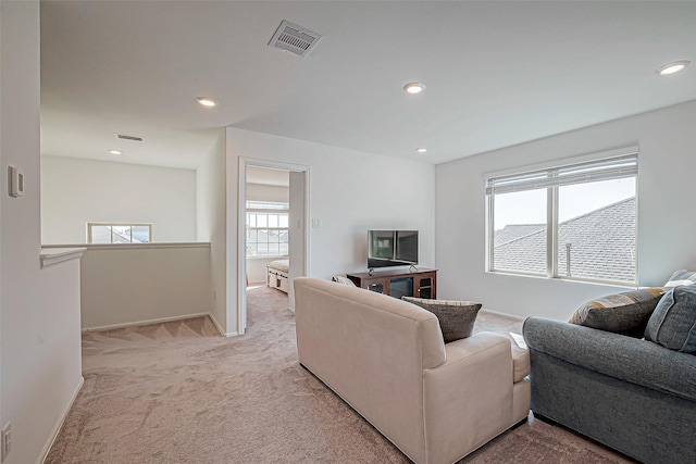 living room with baseboards, recessed lighting, visible vents, and light carpet