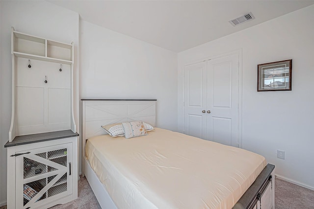 bedroom featuring visible vents, a closet, and light carpet