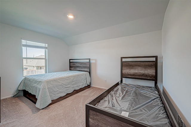 carpeted bedroom featuring baseboards and vaulted ceiling