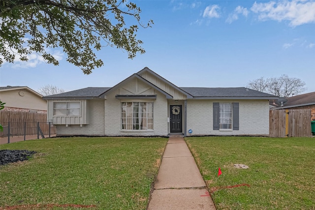 ranch-style house featuring a front lawn, fence, brick siding, and a shingled roof