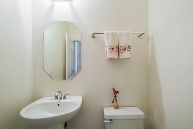 half bathroom featuring toilet and a sink