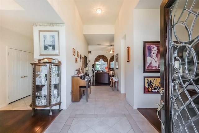 tiled foyer entrance with arched walkways and ceiling fan