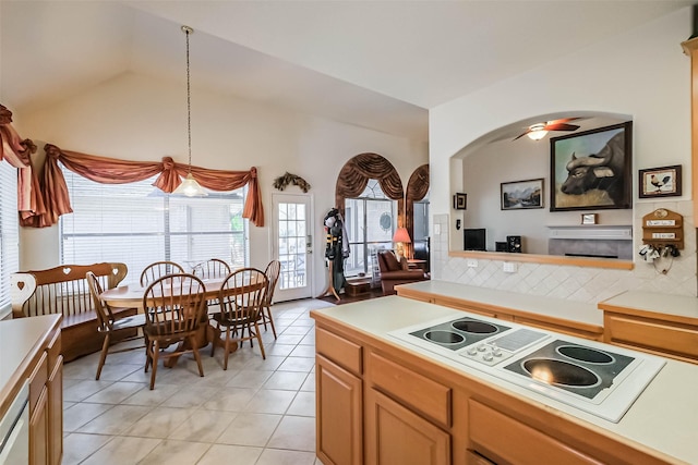 kitchen featuring a ceiling fan, white appliances, light countertops, light tile patterned floors, and vaulted ceiling