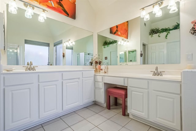 bathroom with a sink, a stall shower, tile patterned floors, and vaulted ceiling