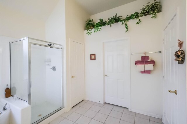 bathroom featuring tile patterned flooring, a stall shower, and a tub