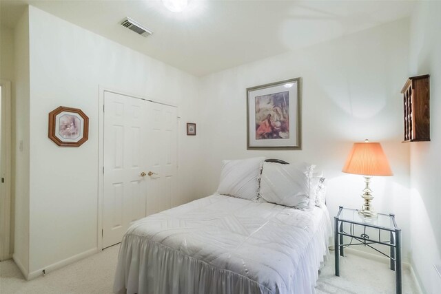 bedroom with visible vents, light colored carpet, and baseboards