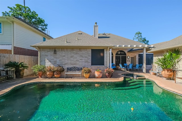 view of pool with a patio area, fence, and a pool with connected hot tub