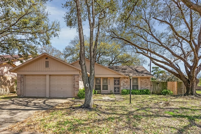 view of front facade with driveway, a garage, and fence