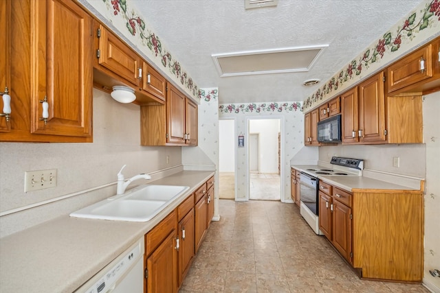 kitchen with wallpapered walls, light countertops, brown cabinetry, white appliances, and a sink