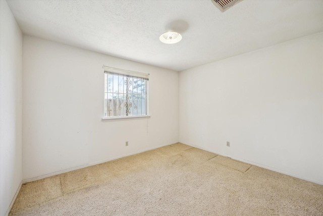 empty room with visible vents, carpet, and a textured ceiling