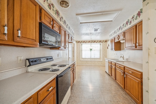 kitchen with electric range, a sink, a textured ceiling, brown cabinetry, and black microwave