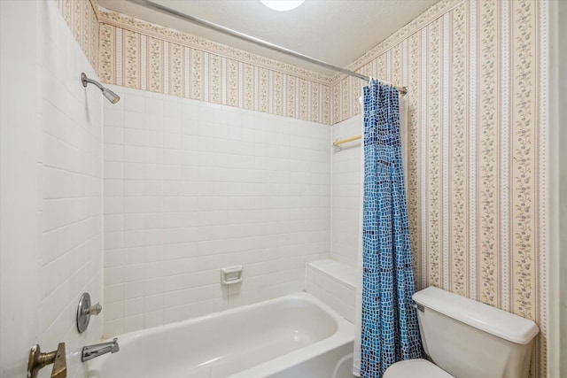 bathroom with wallpapered walls, shower / bath combination with curtain, and toilet