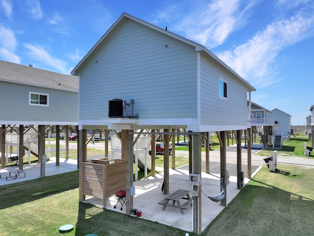 exterior space with a patio, stairway, central AC, a carport, and a lawn